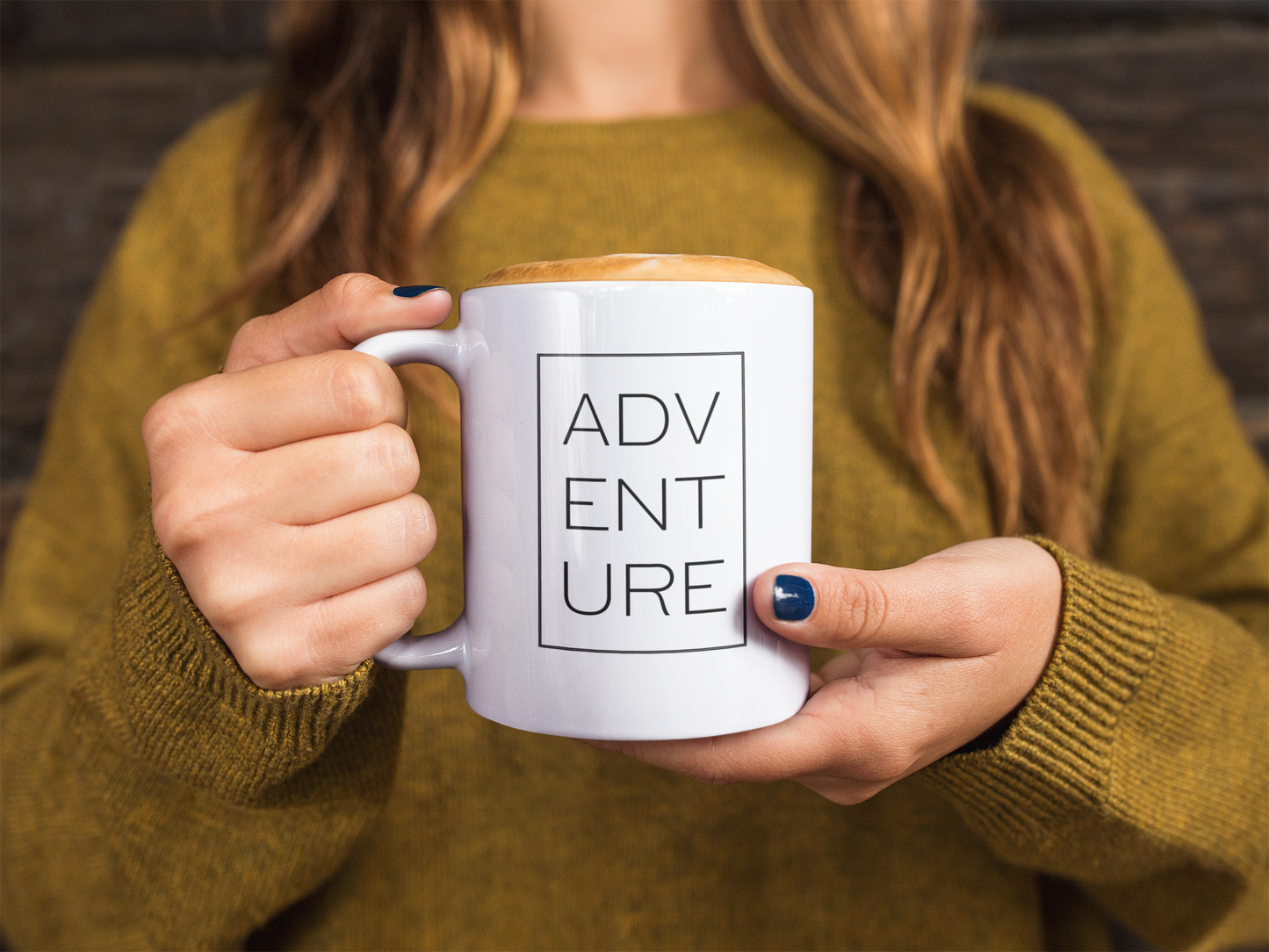 White ceramic mug with hot chocolate held by a woman.