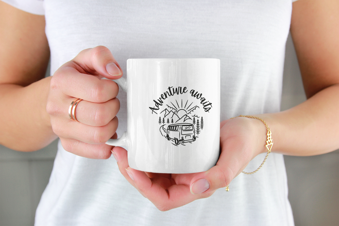 Woman's hands holding a white ceramic coffee mug.