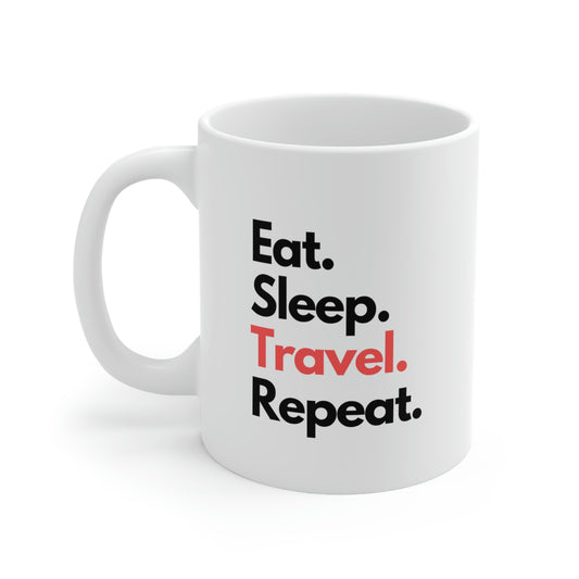 White ceramic coffee mug with words "eat sleep travel repeat" in black and red letters. 